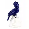 Foto de um(a) Escultura em formato de pássaro azul em porcelana, da categoria de Escultura. Figura de cacatua em louça azul cobalto pousada sobre tronco creme. Mede: 28A x 24 cm de comprimento. Bem conservada. Vendido no marketplace Trésors.