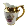 Foto de um(a) Cremeira em porcelana Mauá, da categoria de Cremeiras. Cremeira em porcelana branca da manufatura MAUÁ com farta douração e motivos florais em policromia. Mede 11cm altura x 11cm... Vendido no marketplace Trésors.