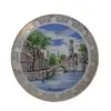 Foto de um(a) Lindo prato de coleção em porcelana, da categoria de Pratos Decorativos. Lindíssimo prato em porcelana, que apresenta uma pintura cênica de Bruges, na Bélgica, destacando um de seus famosos canais... Vendido no marketplace Trésors.