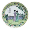 Foto de um(a) Prato oriental decorativo, da categoria de Pratos Decorativos. Antigo prato oriental em porcelana, com cenas de duas mulheres ao meio da natureza. Cercadura em amarelo com detalhes em... Vendido no marketplace Trésors.