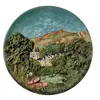 Foto de um(a) Prato de Parede Alemão Anos 70, da categoria de Pratos Decorativos. Prato de parede em terracota policromada e em relevo, década de 1970, procedência alemã motivo: cena de paisagem D: 34,5cm... Vendido no marketplace Trésors.