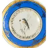 Foto de um(a) Prato Porcelana Dom Pedro, Rio de Janeiro, Década de 1940, da categoria de Pratos Decorativos. Prato de parede policromado e filetado e arabescos em toda a borda. Parte interna com pintura de um passarinho sobre ramos.... Vendido no marketplace Trésors.