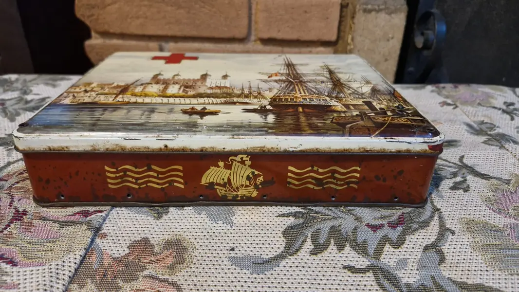 Foto de um(a) Lata vintage de biscoitos fabricada na Inglaterra no século XX, da categoria de Memorabilia de viagem & souvenir. Lata de biscoitos vintage colecionável, produzida originalmente na Inglaterra por volta da década de 1960. O item é feito de... Mostrado de uma perspectiva diferente. Vendido no marketplace Trésors.