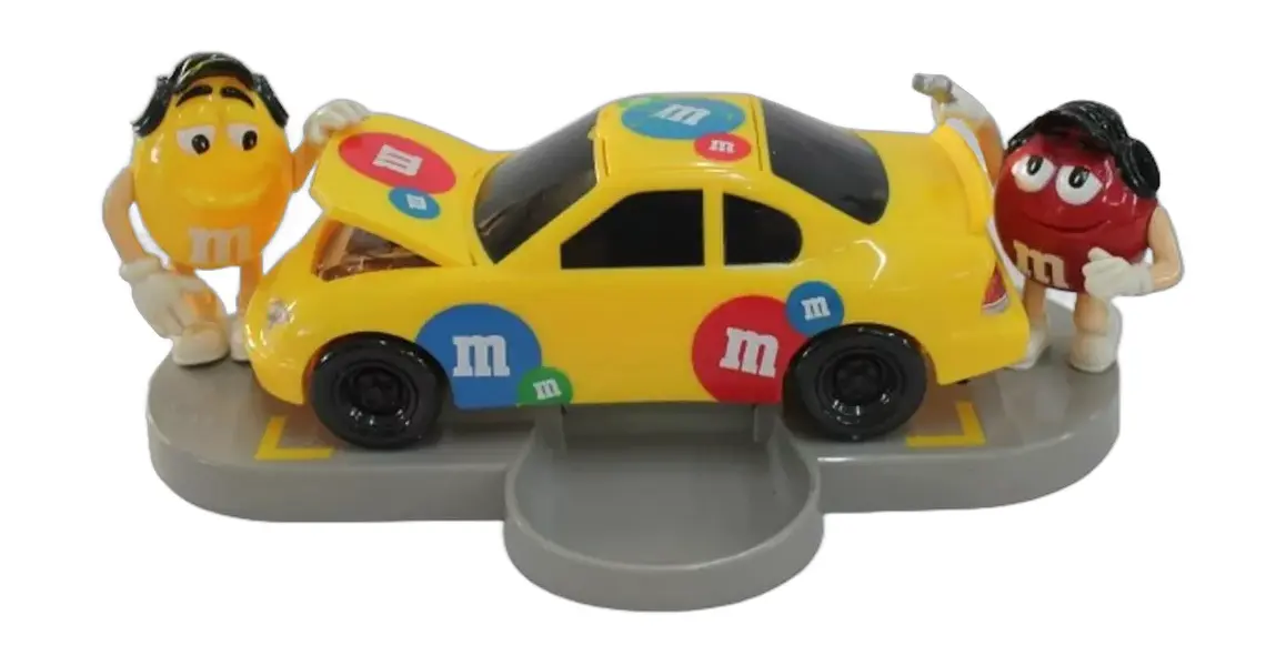 Foto de um(a) Dispenser M & M carro de corrida, da categoria de Brinquedos e Hobbies. Dispenser M&M em formato de carro com dois bonecos em cada lateral, abertura do dispenser fica no teto. Medidas carro 9A x... Vendido no marketplace Trésors.