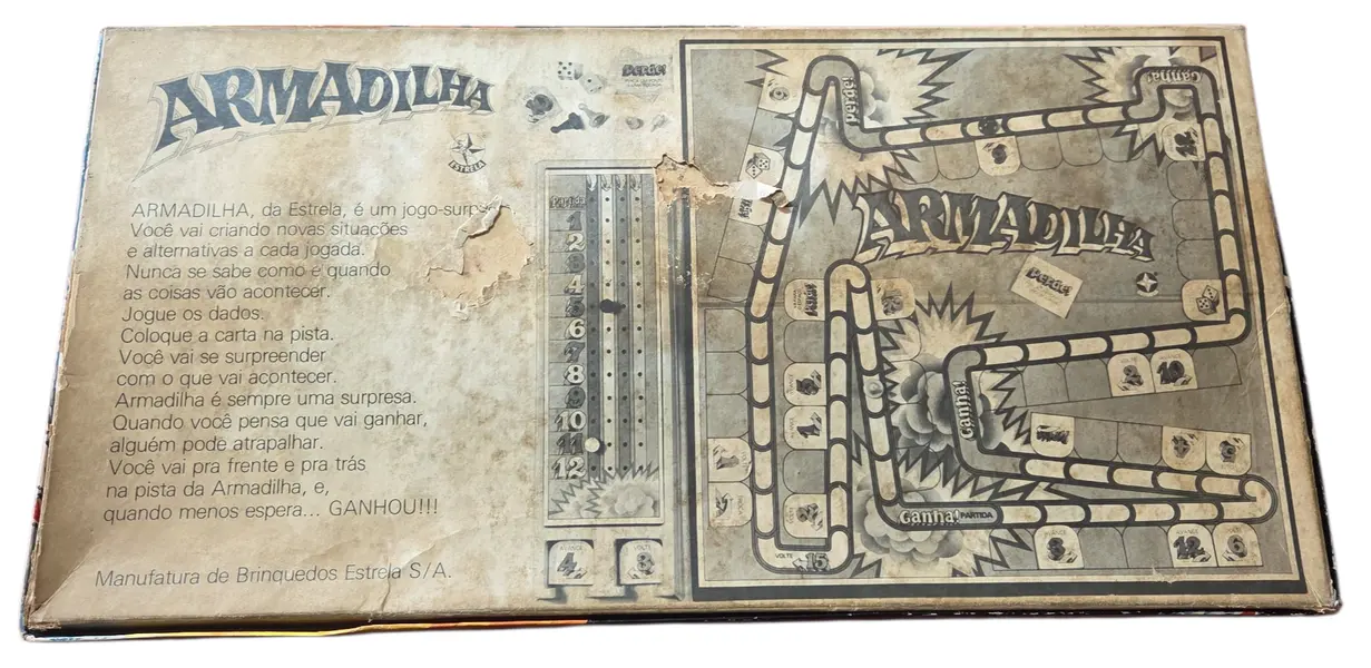 Foto de um(a) Armadilha - O Jogo de Tabuleiro (Estrela), da categoria de Jogos de tabuleiro. É um jogo de percurso e sorte onde você deve ser o primeiro a completar 12 pontos na sua trilha de marcação. A "armadilha"... Mostrado de uma perspectiva diferente. Vendido no marketplace Trésors.