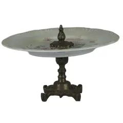 Foto de um(a) Fruteira em metal, da categoria de Fruteiras. Fruteira de bronze com prato em porcelana pintado a mão (possivelmente adaptado). Em bom estado de conservação. Vendido no marketplace Trésors.