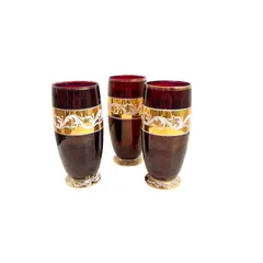 Foto de um(a) ​Trio de copos altos de vidro da década de 50, da categoria de Copos. Trio de copos altos de vidro da década de 50, pintados em bordô, dourado e branco. Marcas do tempo e uso e um com mínimo... Vendido no marketplace Trésors.