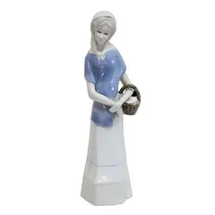 Foto de um(a) Escultura de dama em porcelana, da categoria de Escultura. Delicada escultura de dama com farto cachecol na tonalidade azul e carregando cesto no braço esquerdo. Peça bastante... Vendido no marketplace Trésors.
