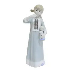Foto de um(a) Escultura de porcelana vitrificada, da categoria de Escultura. Linda escultura de porcelana vitrificada, retratando uma menina em pé com expressão delicada, segurando uma boneca nos... Vendido no marketplace Trésors.