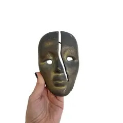 Foto de um(a) ​ Máscara decorativa indiana em metal para pendurar, da categoria de Objetos de parede esculturais. Máscara decorativa para pendurar. Em metal, com suporte. Marcas do tempo e uso como nas fotos. Medidas: 14x9cm. Vendido no marketplace Trésors.