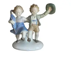 Foto de um(a) Antigo Bibelô Figurine Meninos Brincando Porcelana Alemã, da categoria de Escultura. Antiga figurine/bibelô em porcelana artística alemã. Cores típicas de meados do século XX. Muito decorativa e colecionável.... Vendido no marketplace Trésors.