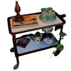 Foto de um(a) Carrinho de chá 60’s em Jacarandá, da categoria de Carrinhos de bar e auxiliares. Carrinho de chá da década de 60 em jacarandá, tampos retangulares em fórmica branca com uma alça em uma lateral torneada,... Vendido no marketplace Trésors.