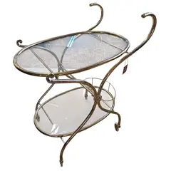 Foto de um(a) Carrinho de Chá Italiano – Bronze e Latão com Vidro Temperado, da categoria de Carrinhos de bar e auxiliares. Exemplar sofisticado do design europeu, este carrinho de chá (ou carrinho bar) combina a robustez do bronze com o brilho... Vendido no marketplace Trésors.