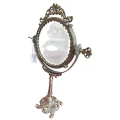 Foto de um(a) Espelho de Bancada em Bronze - Moldura Trabalhada com Fundo em Porcelana Floral, da categoria de Espelhos. Encantador espelho de bancada estilo vintage, uma peça decorativa clássica que une a robustez do bronze à delicadeza da... Vendido no marketplace Trésors.