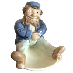 Foto de um(a) Antigo Bibelô De Coleção Art Deco Porcelana Alemã, da categoria de Escultura. Bibelô em porcelana alemã, representando senhor que balança na cadeira, período Art Deco. Década de 1940.Medidas 12x12xcm. Vendido no marketplace Trésors.