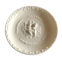 Foto de um(a) Antigo Pratinho De Parede Em Biscuit Francês, da categoria de Pratos Decorativos. Antigo pratinho de parede em biscuit francês ricamente decorado com querubins e flores. Em perfeito estado. Mede: 11cm. Vendido no marketplace Trésors.