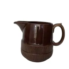Foto de um(a) Jarra Esmaltada em Terracota, Déc. 1940, da categoria de Garrafas, potes e jarros. Jarra esmaltada em terracota marrom com relevo na parte de baixo, década de 1940. A: 16cm / D: 15cm Peso: 910g. Vendido no marketplace Trésors.