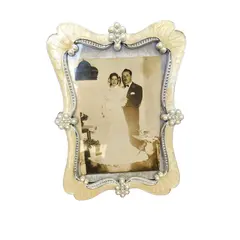 Foto de um(a) Porta Retrato Pérolas Anos 2000, da categoria de Porta retratos. Porta retrato em em resina e pérolas, década de 2000 A: 18 cm L: 12,5 cm Peso: 130 g. Vendido no marketplace Trésors.