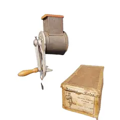 Foto de um(a) Ralador de Queijo e Frutas, Marca Yara N.200, Década de 1940, da categoria de Acessórios de cozinha. Máquina de ralar queijo, coco e frutas. Em ferro, folha de flanders e socador e manivela em madeira, com embalagem original... Vendido no marketplace Trésors.