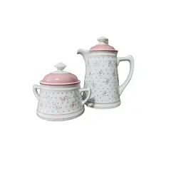 Foto de um(a) Bule e Açucareiro Porcelana Real, Década de 1990, da categoria de Bules. Combo com bule e açucareiro em porcelana branca e estampa de flores em rosa e cinza. Bule com trava na tampa e tranca pingo.... Vendido no marketplace Trésors.