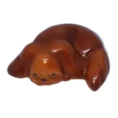 Foto de um(a) Antiga Linda Escultura Bibelô Cachorro Em Porcelana Alemã, da categoria de Modelos e estatuetas. Antigo bibelô de cachorro deitadinho em porcelana alemã. Década de 1950. Medidas 9x13cm. Vendido no marketplace Trésors.