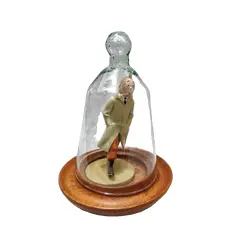 Foto de um(a) As Aventuras de Tintim, Hergé, com Redoma de Vidro, da categoria de Memorabilia de mídia e entretenimento. Tintim com capa de chuva, do livro o caranguejo das pinças de ouro. Figura icônica do seu criador hergé no ano de 1926. A:... Vendido no marketplace Trésors.
