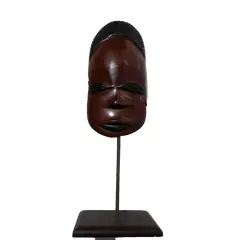 Foto de um(a) Máscara Africana em Madeira, da categoria de Modelos e estatuetas. Máscara africana esculpida em madeira com base também em madeira. Peso: 272g A: 32cm L: 11cm P: 8cm. Vendido no marketplace Trésors.