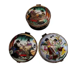 Foto de um(a) Combo com Três Caixas em Porcelana Estampa Cenas Japonesas, Década de 1980, da categoria de Cestos e Caixas. Combo com três caixas em porcelana. Estampas com cenas japonesas, gueixas e flores. Fecho dourado e contorno da caixa com... Vendido no marketplace Trésors.