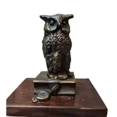Foto de um(a) Coruja Bronze Anos 80, da categoria de Escultura. Coruja em broze com base em imbuia. A: 12,7 cm / L: 5,6 cm / P: 5,6 cm Base: 12,5 x 10 x 1,5 cm Peso: 521 g. Vendido no marketplace Trésors.