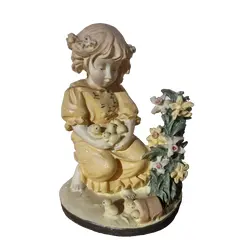 Foto de um(a) Bela escultura decorativa em resina, da categoria de Modelos e estatuetas. Esta delicada escultura decorativa retrata uma menina ajoelhada vestindo um gracioso vestido amarelo, segurando... Vendido no marketplace Trésors.