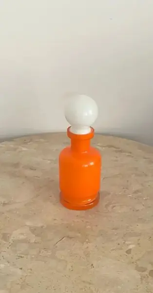 Foto de um(a) Aphothecary bottle, vidro de colônia em murano, da categoria de Outros colecionáveis. Frasco em murano na cor laranja com a tampa branca. Peça original em vidro Murano, artesanal e colecionável. Design elegante... Mostrado de uma perspectiva diferente. Vendido no marketplace Trésors.