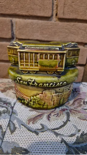 Foto de um(a) Raríssimo souvenir norte-americano, caixinha de música, da categoria de Outros objetos decorativos. Linda e rara caixinha musical movida à corda, produzida em meados da década de 70, em cerâmica vitrificada, entalhada com 3... Mostrado de uma perspectiva diferente. Vendido no marketplace Trésors.