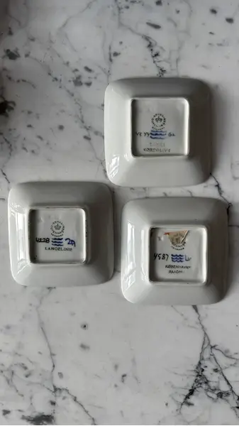 Foto de um(a) Antigo Prato Decorativo Sereia Porcelana Royal Copenhagen, da categoria de Pratos Decorativos. ~ Royal Copenhagen ~ Trio de pratinhos decorativos em porcelana artística. Peças catalogadas. Medidas 10x10cm cada. Mostrado de uma perspectiva diferente. Vendido no marketplace Trésors.