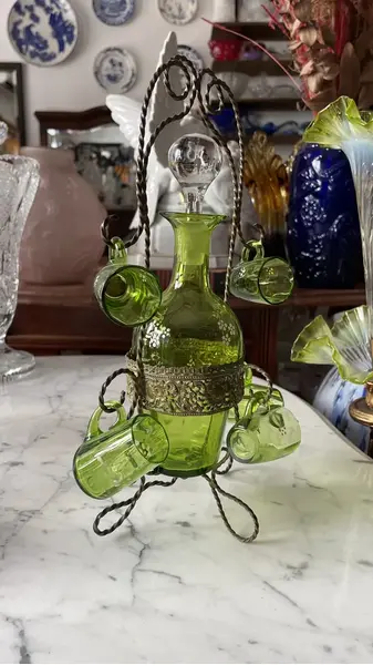 Foto de um(a) Antiga Garrafa Licoreira Copinhos Murano Veneziano Verde, da categoria de Garrafas, potes e jarros. Antiga e preciosa licoreira com cinco copinhos em vidro artístico veneziano na cor verde esmeralda, acompanha o suporte... Mostrado de uma perspectiva diferente. Vendido no marketplace Trésors.
