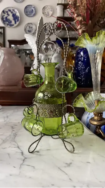 Foto de um(a) Antiga Garrafa Licoreira Copinhos Murano Veneziano Verde, da categoria de Garrafas, potes e jarros. Antiga e preciosa licoreira com cinco copinhos em vidro artístico veneziano na cor verde esmeralda, acompanha o suporte... Mostrado de uma perspectiva diferente. Vendido no marketplace Trésors.