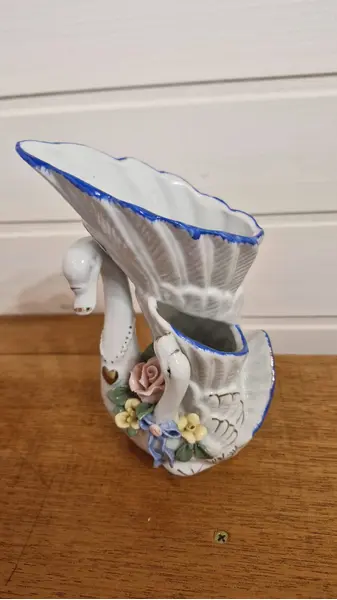 Foto de um(a) Excepcional par de floreiras em porcelana, da categoria de Vasos. Encantador par de vasos vintage confeccionado em porcelana branca com um design ornamental clássico no formato de cisnes... Mostrado de uma perspectiva diferente. Vendido no marketplace Trésors.