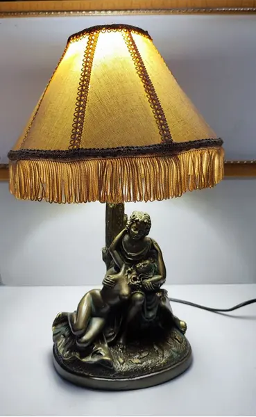 Foto de um(a) Abajur Cena Galante em Resina Italiana, da categoria de Abajures. Abajur cena galante em resina italiana com pátina bronze envelhecida e oxidada, cúpula gomada com tecido cru e passamanaria... Mostrado de uma perspectiva diferente. Vendido no marketplace Trésors.