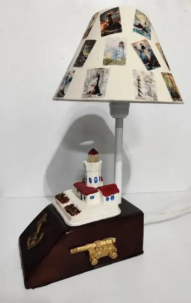 Foto de um(a) Abajur Náutico, da categoria de Abajures. Abajur náutico: base em madeira com aplique de âncora, canhão antigo e farol policromado em resina. Cúpula em tecido de... Mostrado de uma perspectiva diferente. Vendido no marketplace Trésors.