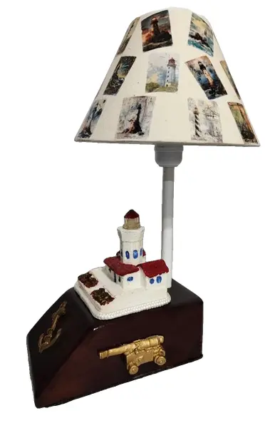 Foto de um(a) Abajur Náutico, da categoria de Abajures. Abajur náutico: base em madeira com aplique de âncora, canhão antigo e farol policromado em resina. Cúpula em tecido de... Vendido no marketplace Trésors.