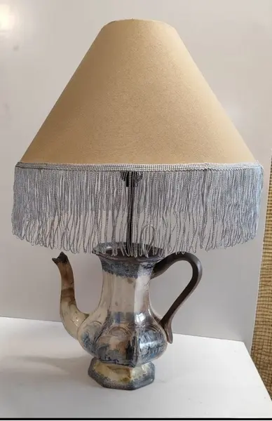 Foto de um(a) Luminária Bule Inglês, da categoria de Abajures. Bule inglês antigo sem restauro transformado em luminária, interruptor no próprio bocal, cúpula em tecido com franja de seda... Mostrado de uma perspectiva diferente. Vendido no marketplace Trésors.