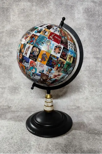Foto de um(a) Globo Tintim, Herge, da categoria de Globos. Globo tintim globo com esfera giratória de plástico decoupado com imagens do tintim, estrutura em ferro com detalhes em... Mostrado de uma perspectiva diferente. Vendido no marketplace Trésors.
