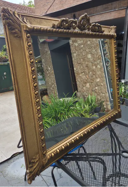 Foto de um(a) Espelho Antigo Dourado em Madeira com Vidro Bisotê, da categoria de Espelhos. Espelho antigo com moldura em madeira, acabamento dourado e detalhes entalhados. Possui vidro bisotê, que valoriza o... Mostrado de uma perspectiva diferente. Vendido no marketplace Trésors.