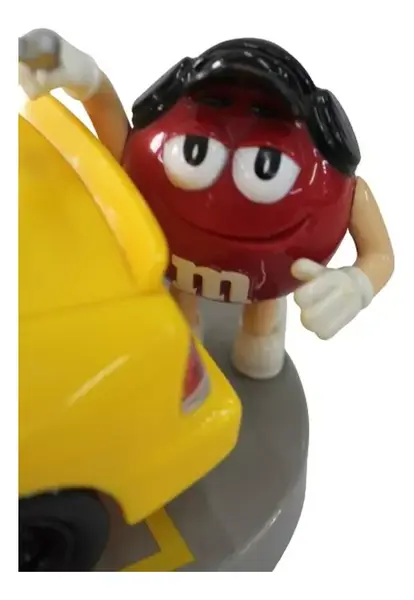 Foto de um(a) Dispenser M & M carro de corrida, da categoria de Brinquedos e Hobbies. Dispenser M&M em formato de carro com dois bonecos em cada lateral, abertura do dispenser fica no teto. Medidas carro 9A x... Mostrado de uma perspectiva diferente. Vendido no marketplace Trésors.