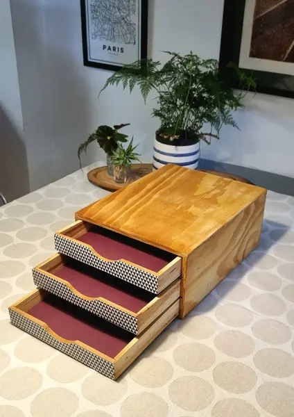 Foto de um(a) gaveteiro/organizador de mesa, da categoria de Cestos e Caixas. Gaveteiro de mesa, antigo, em madeira clara, padrão compensado, encerada, com frente revestida em papel acid free.3 gavetas... Mostrado de uma perspectiva diferente. Vendido no marketplace Trésors.