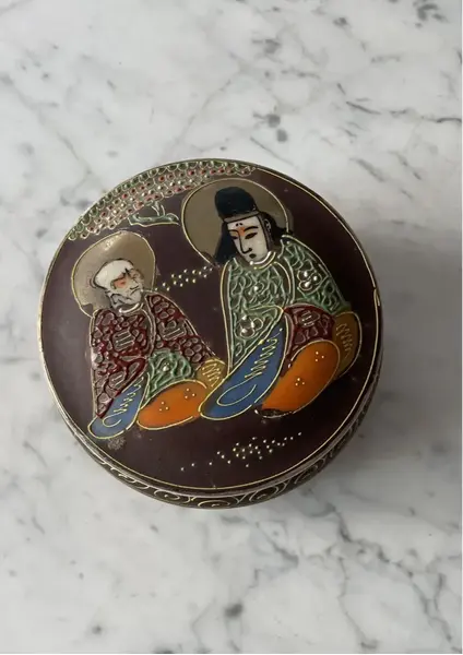 Foto de um(a) Antiga Caixa Decorativa Porta Joias Porcelana Japão Satsuma, da categoria de Porta-Jóias. Antiga caixinha oriental em porcelana japonesa Satsuma. Decoração típica, ricamente pintada à mão. Medidas 6x12cm. Mostrado de uma perspectiva diferente. Vendido no marketplace Trésors.