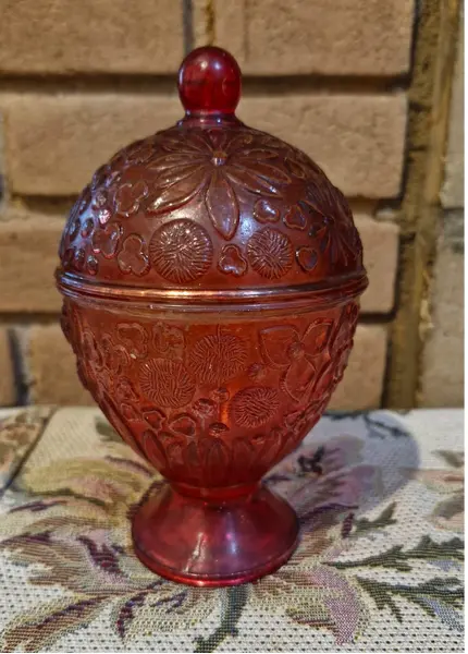 Foto de um(a) 2 belas bomboniéres, sendo uma da Avon anos 60, da categoria de Garrafas, potes e jarros. Duas belas bombonières de vidro decorativas (potes com tampa), sendo a vermelha um modelo clássico de colecionador da marca... Mostrado de uma perspectiva diferente. Vendido no marketplace Trésors.