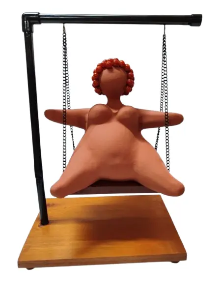 Foto de um(a) Escultura Feminina em Terracota, Peça Única, da categoria de Escultura. Escultura feminina em terracota no balanço, cabelos são de contas na cor coral, balanço em ferro com madeira e base com pés... Vendido no marketplace Trésors.