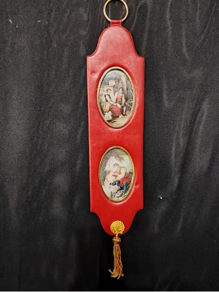 Foto de um(a) Peça Decorativa de Parede com Cenas Galante, Década de 1960, da categoria de Objetos de parede esculturais. Peça decorativa de parede ainda com a embalagem original, com gravuras galantes policromadas, em vinil e metal com tassel... Mostrado de uma perspectiva diferente. Vendido no marketplace Trésors.