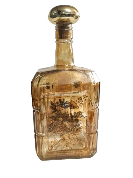 Foto de um(a) Garrafa Âmbar 70'S, da categoria de Garrafas, potes e jarros. Garrafa âmbar com pintura floral em dourado, década de 1970.A: 24,5 cm L: 11 cm P: 8 cm / peso: 765 g. Vendido no marketplace Trésors.