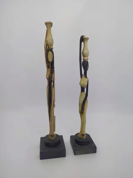 Foto de um(a) Par de esculturas africanas em madeira, da categoria de Escultura. Par de esculturas africanas em madeira, pintada à mão, retratando mulheres carregando baldes. Mede A: 31cm. Mostrado de uma perspectiva diferente. Vendido no marketplace Trésors.